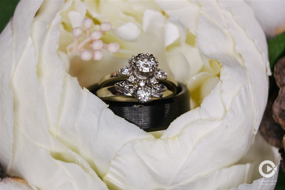 Photo of wedding rings in a flower detail shot taken by Jeff with Complete Weddings + Events