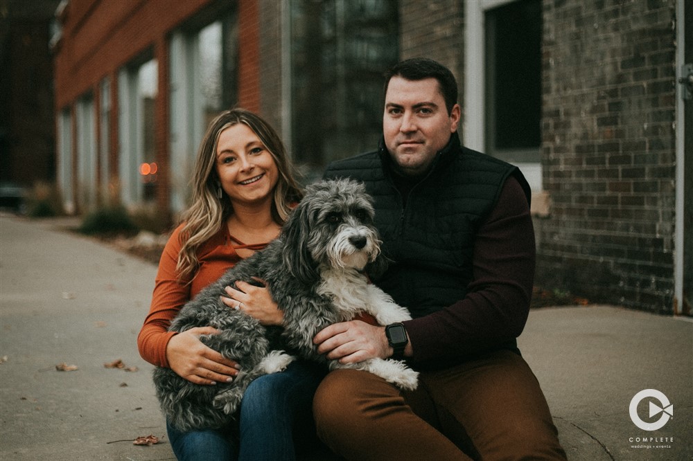 Engaged couple taking photos during their engagement shoot and included their dog