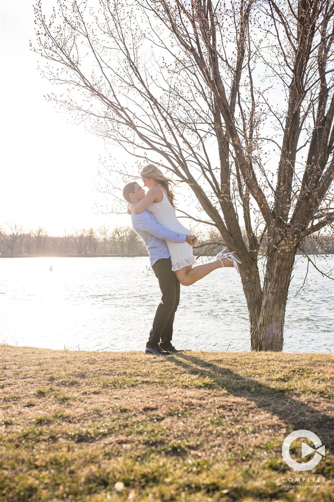 Shea holding his fiance up in the air during engagement shoot Minnesota