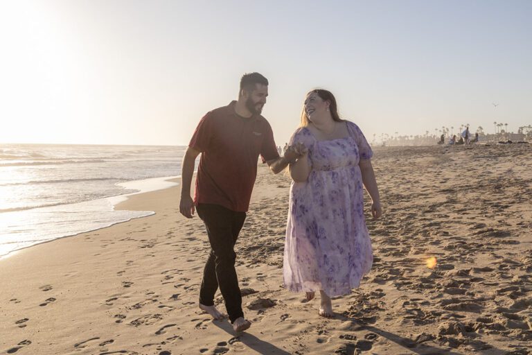 engaged couple walking on the beach