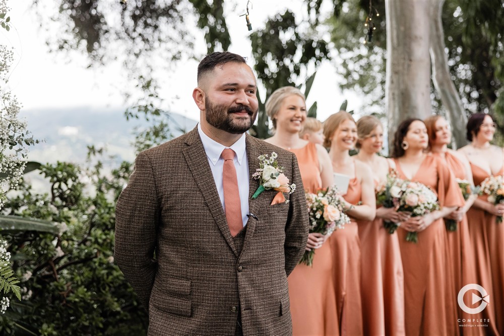 groom watching bride walk down the aisle