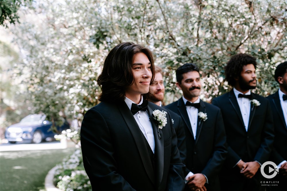 groom watching bride walk down the aisle