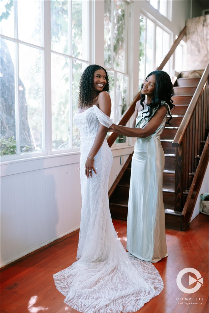 mom helping bride with dress