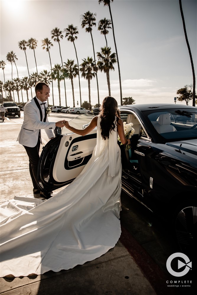 Couple exiting ceremony in luxury car