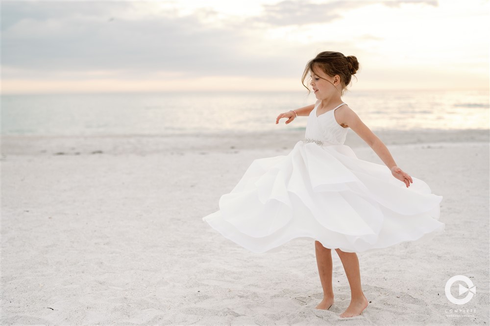 Sarasota beach wedding flower girl twirl.