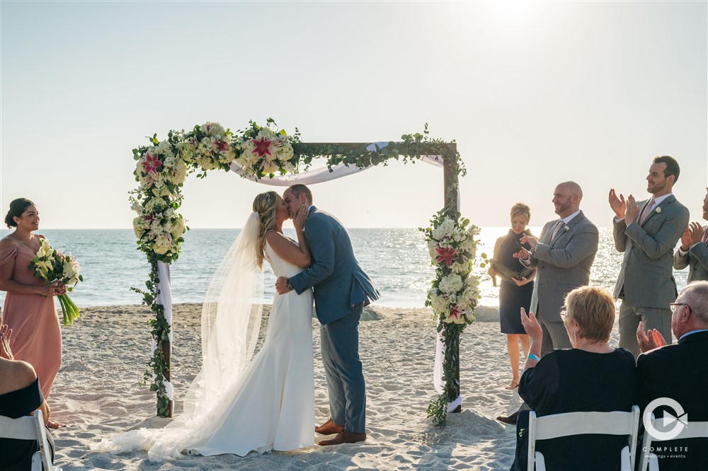 Bride and Groom kiss at altar at Zota Beach Resort