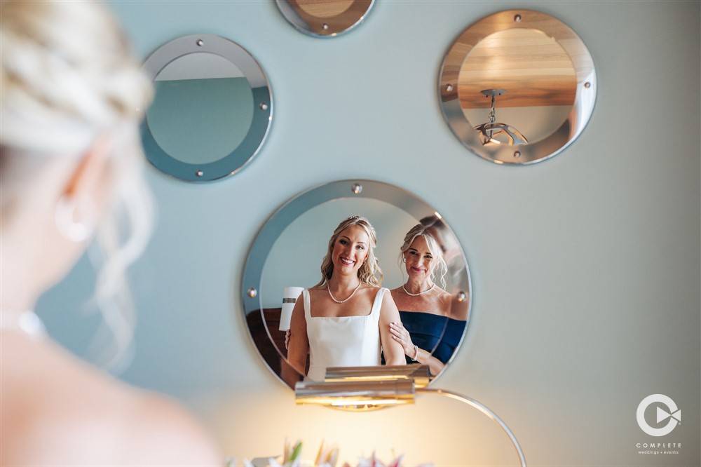 Bride with mother both reflected in round mirrors