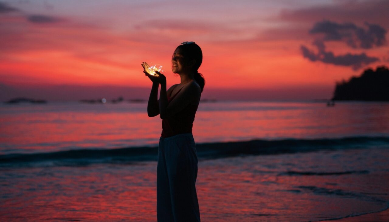 Young woman on beach at a magical red sunset to starlight