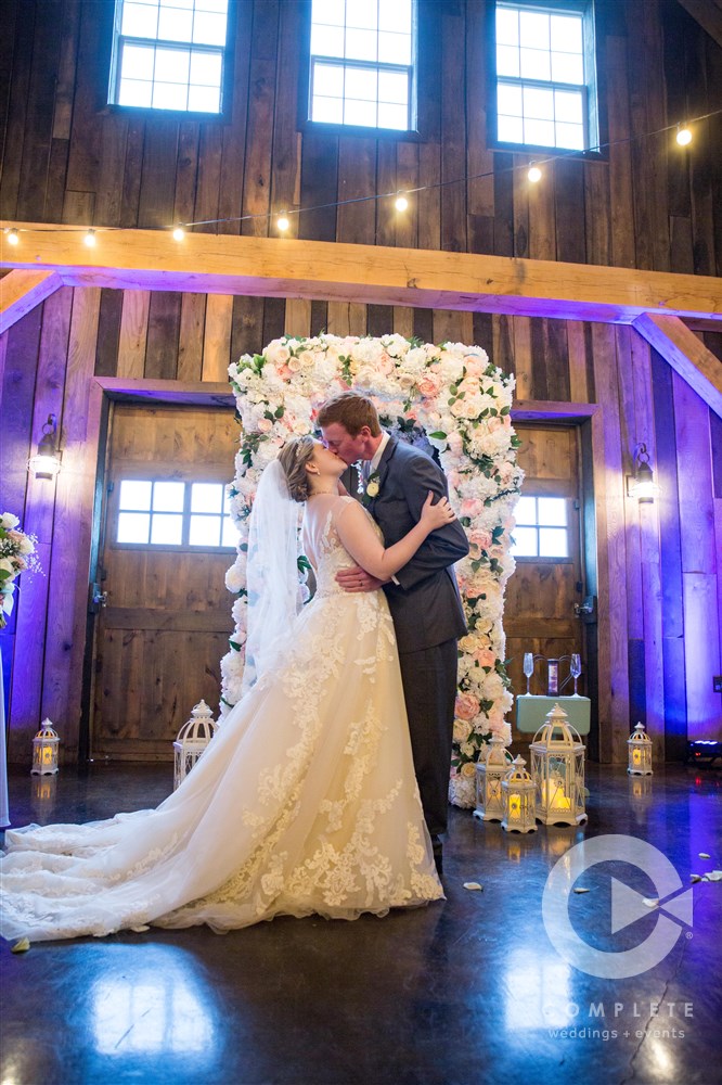 first kiss during ceremony inside barn at Sycamore Creek Family Ranch