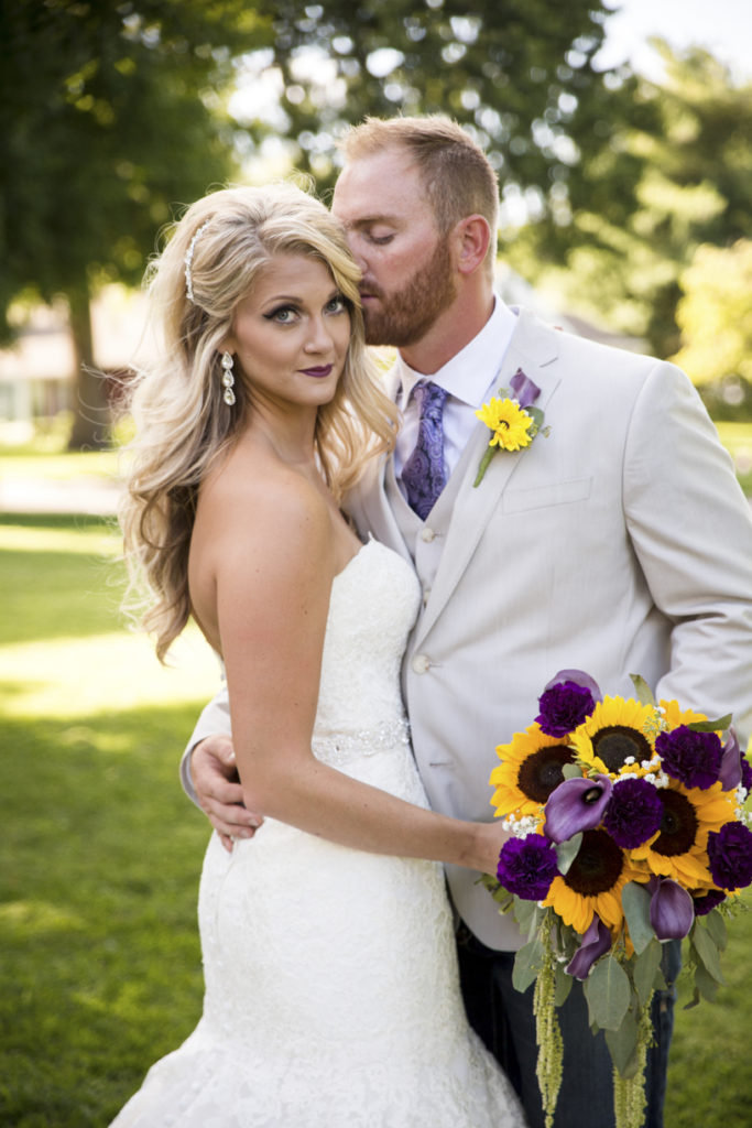 Fall outdoor wedding picture with sunflower bouquet
