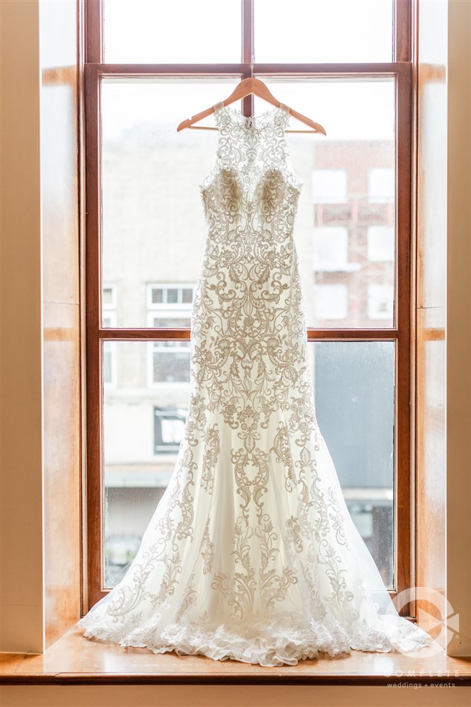 lace wedding dress hanging in window