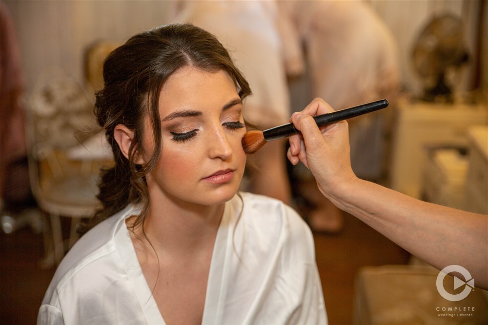 bride having makeup done on wedding day