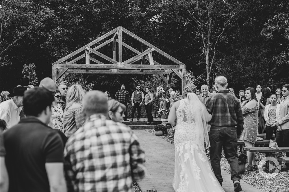 bride walks down aisle with dad black and white