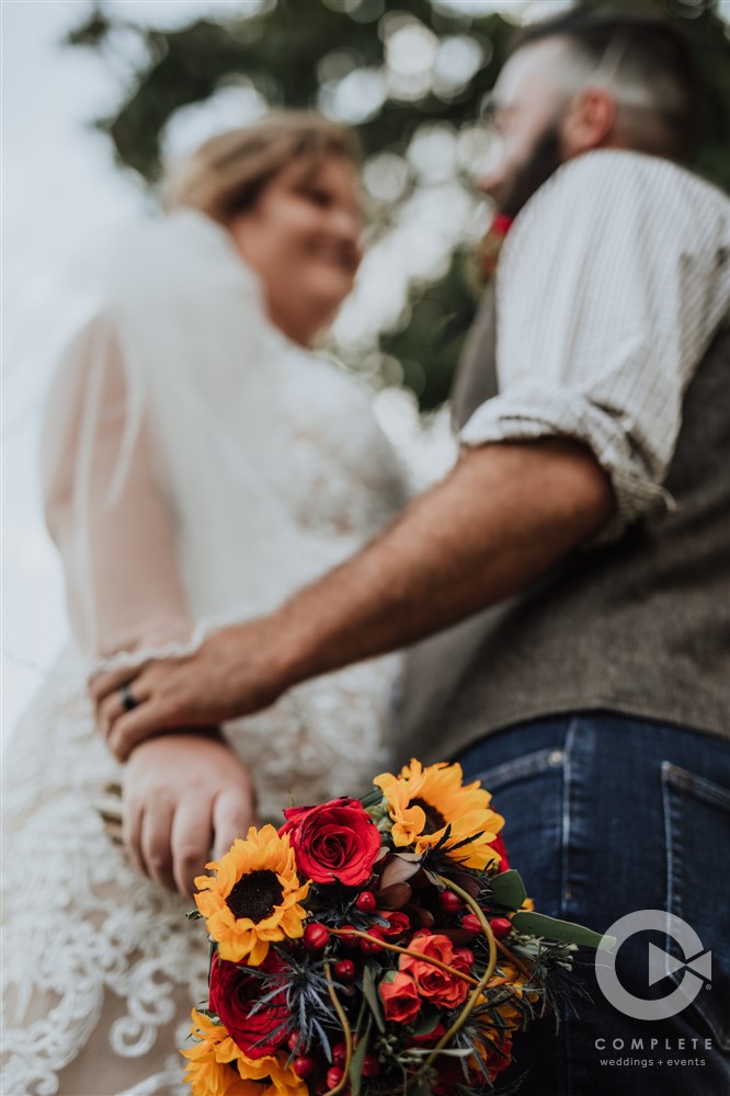 bride and groom out of focus with bouquet