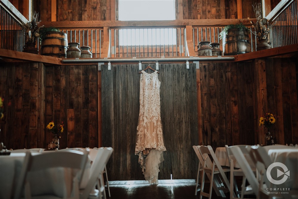 wedding dress hanging above rustic doors