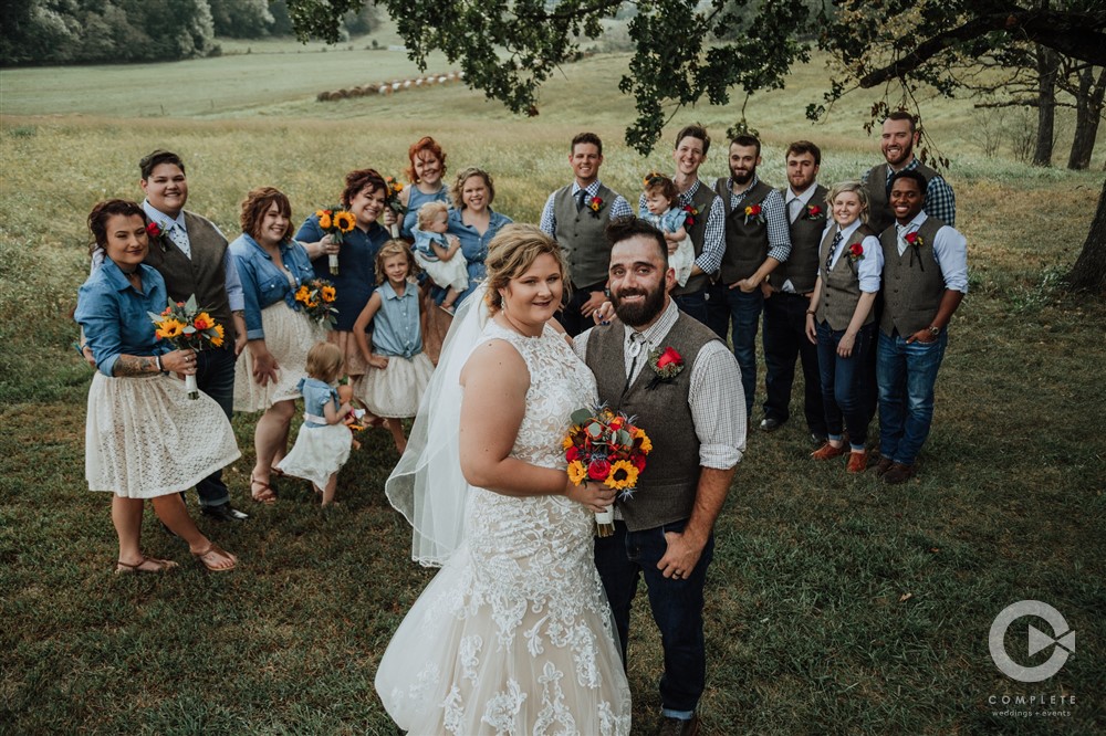 bridal party smiling under a tree