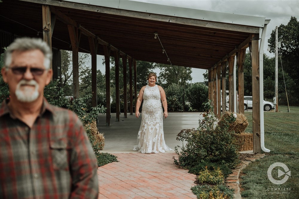 Bride standing under barn overhang