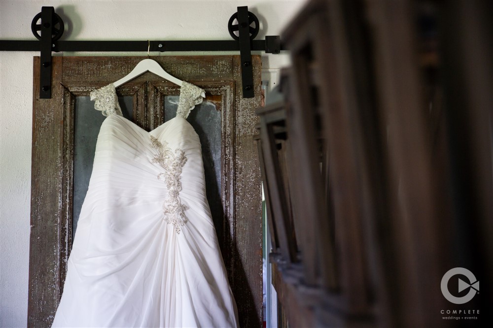 wedding dress hanging from rustic door