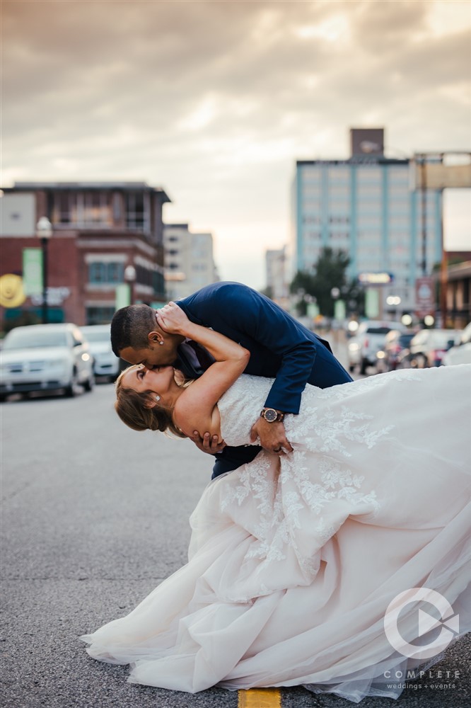 bride and groom kissing in front of downtown springfield