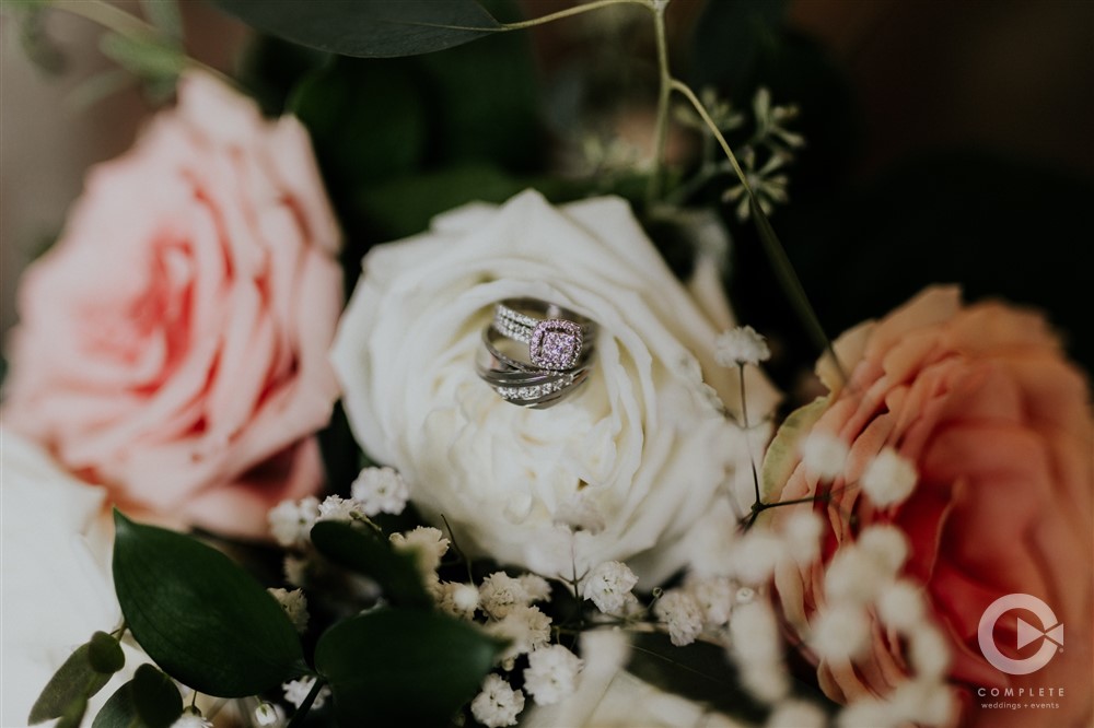 wedding rings tucked into pink and white roses