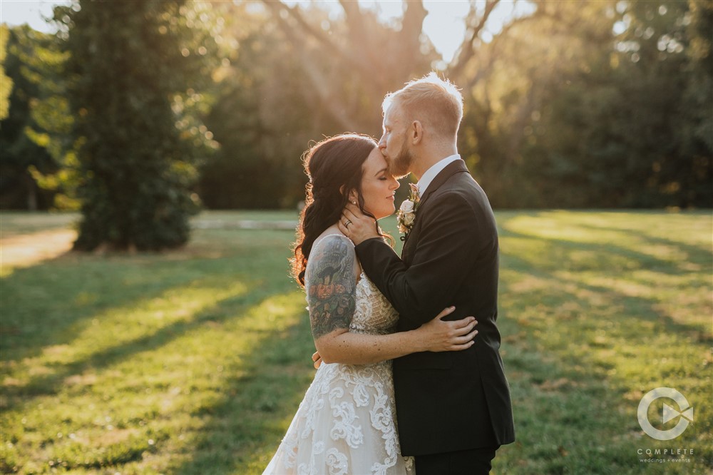 Micro Wedding Packages in Springfield | groom kisses bride on forehead at sunset