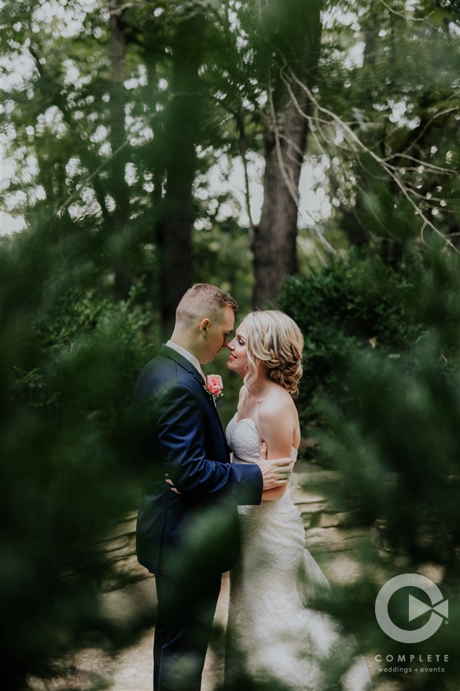 bride and groom touch noses in a forest
