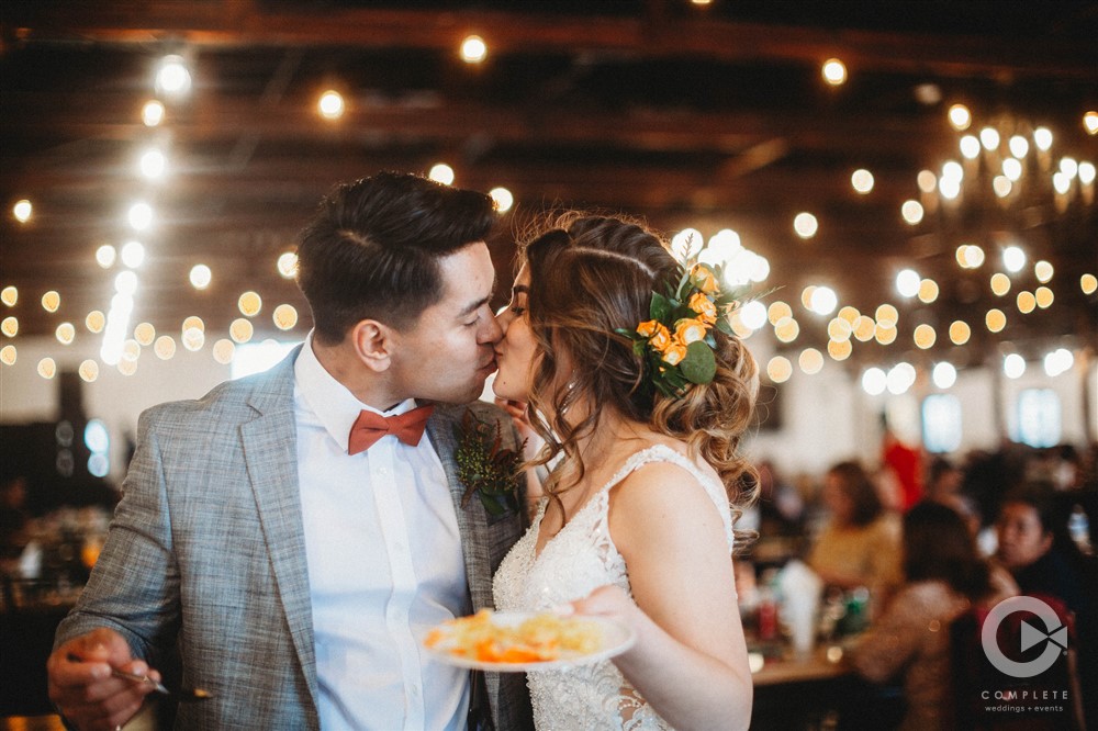 bride and groom kiss with floral accents