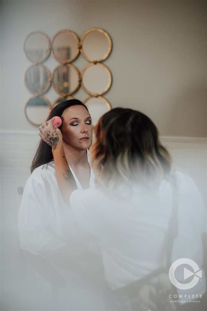 bride closing eyes while her makeup is done