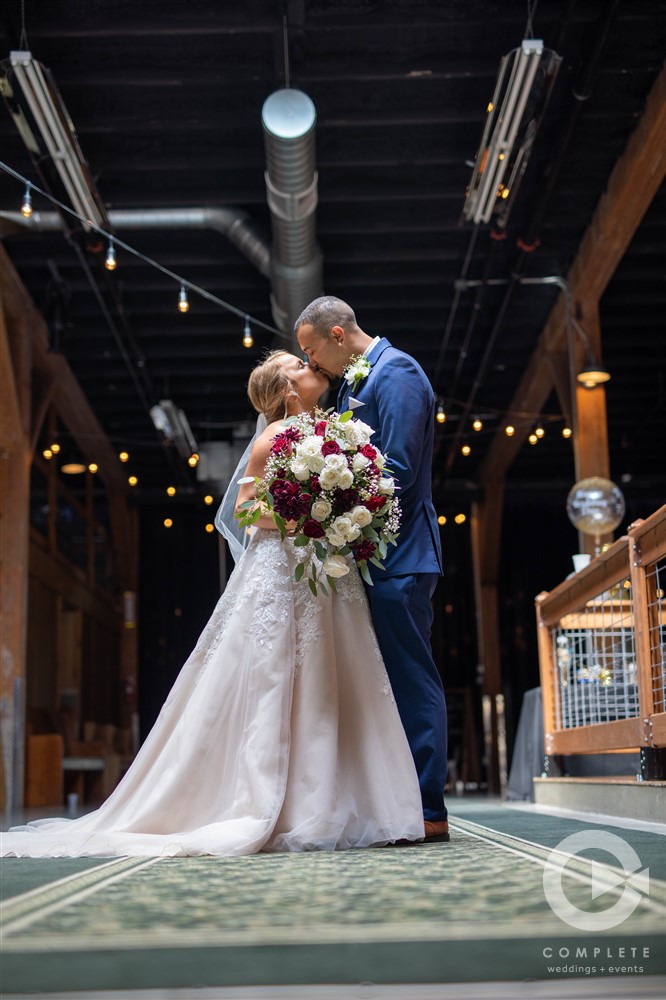 bride and groom kiss at old glass place