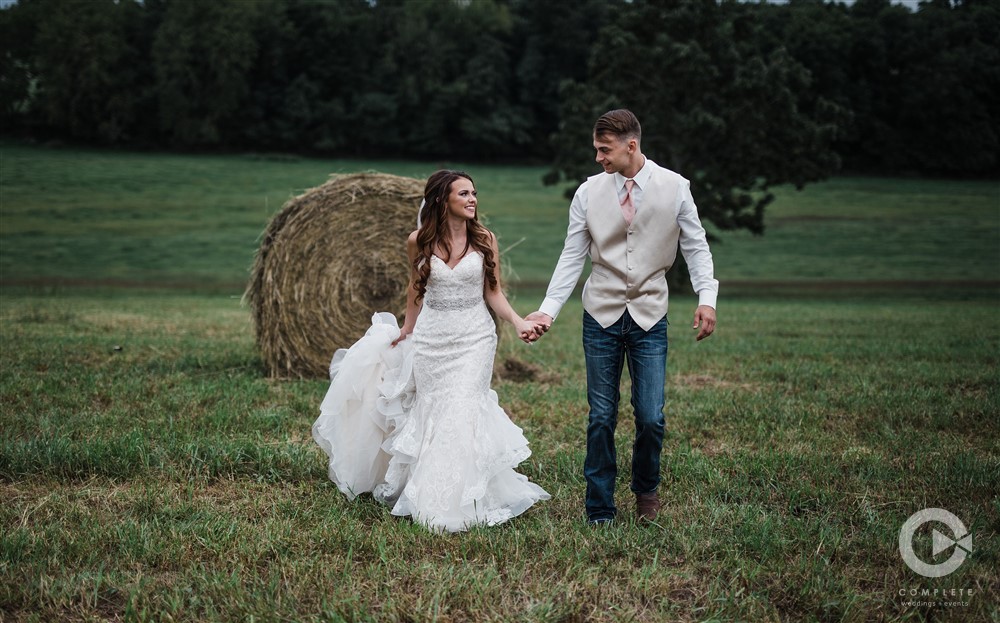 Bride and Groom in field with hay bails