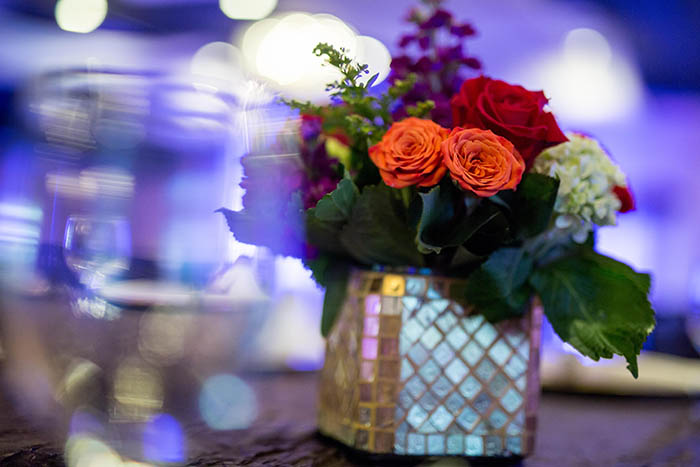 Purple up-lighting with red and orange floral center pieces