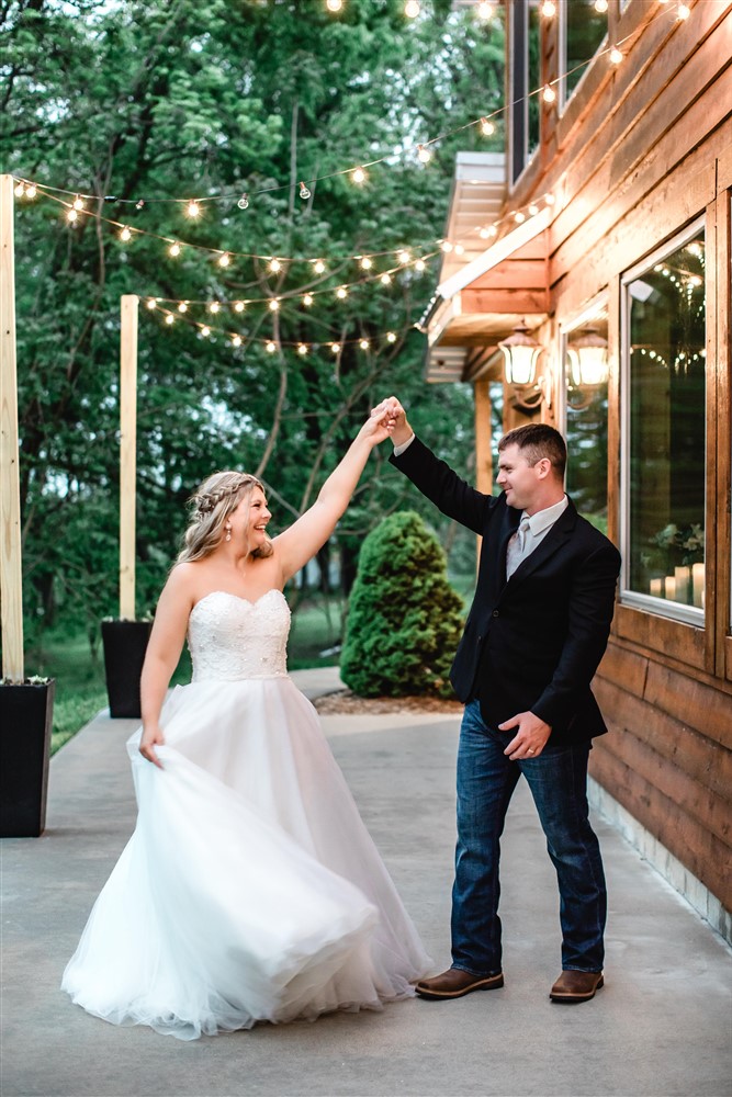 bride and groom dancing under twinkle lights at Venue at Stockton Lake