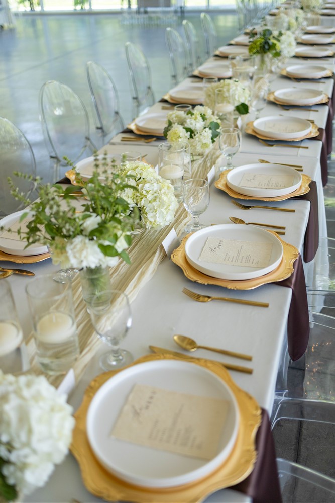 White and gold table scape design with acrylic chairs at Greenhouse Two Rivers