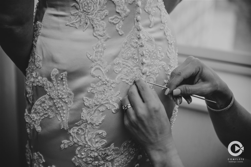Bride Being Sewn into Dress