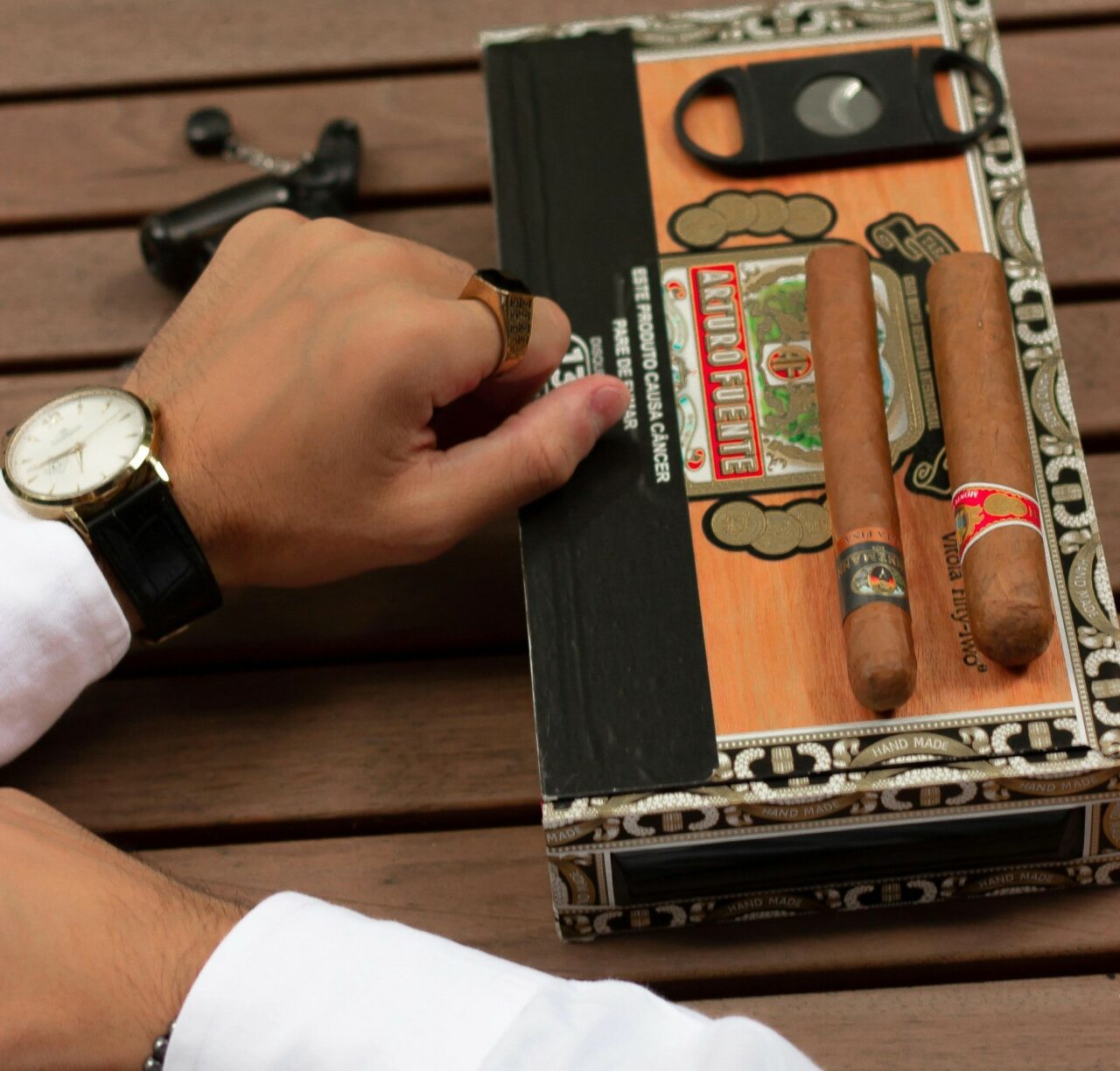 Photo by Gabriel Lima: https://www.pexels.com/photo/close-up-of-man-in-a-white-shirt-sitting-at-a-table-with-a-cigar-box-15767595/