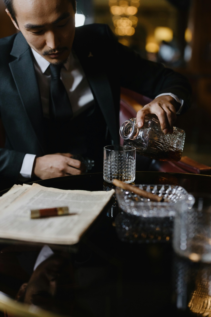 Man pours Whiskey into a tumbler in a Cigar Bar