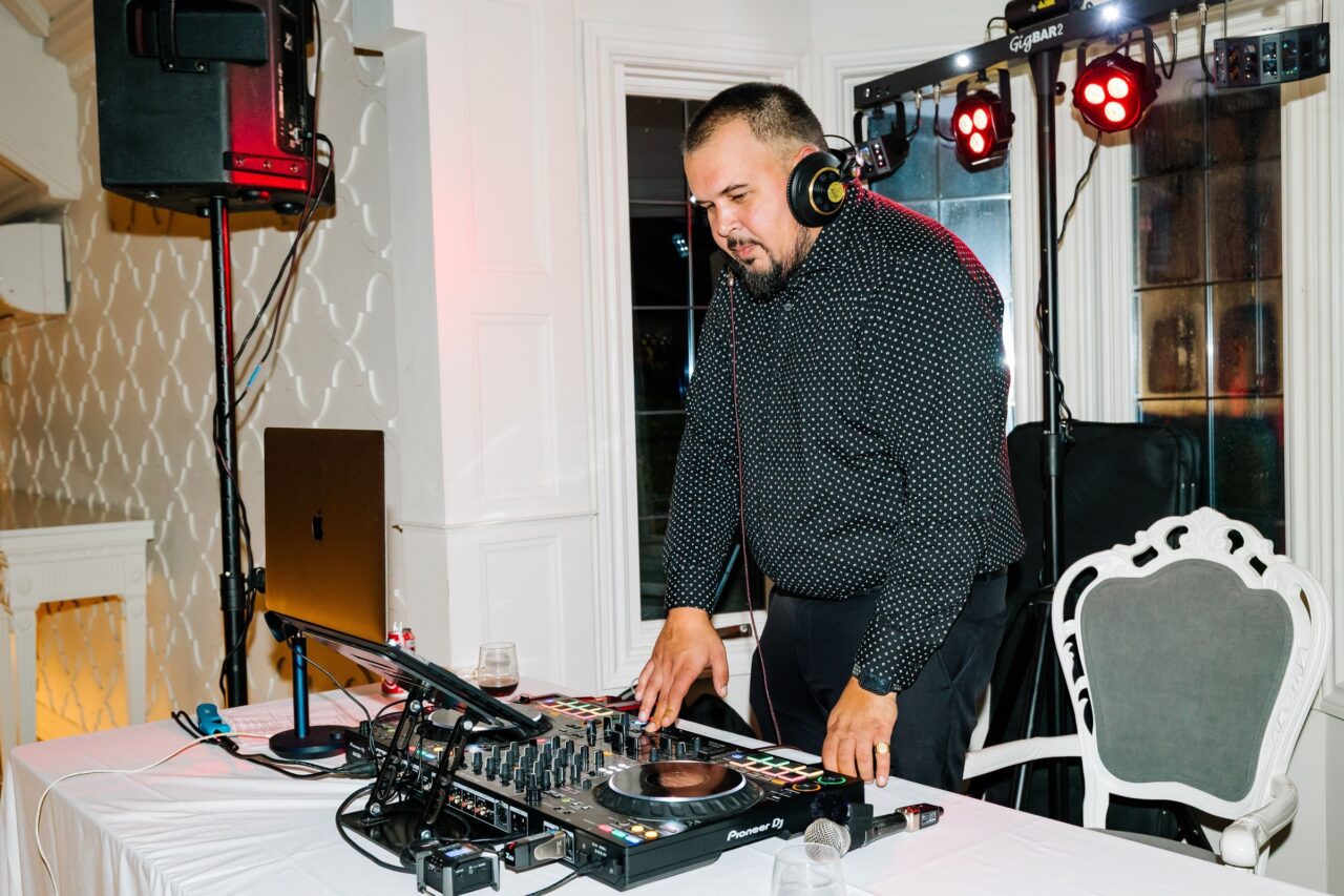 DJ Norman stands at DJ booth