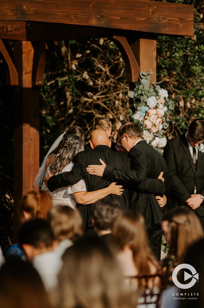 bride, groom, and father hug