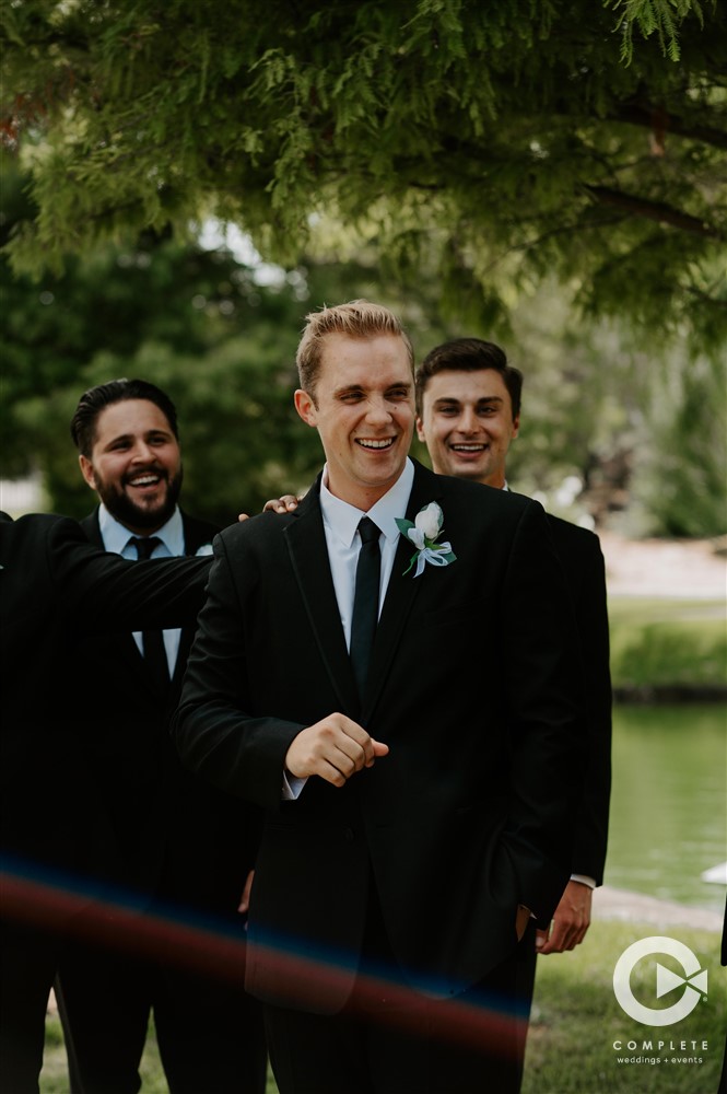groom in black and white suit and tie