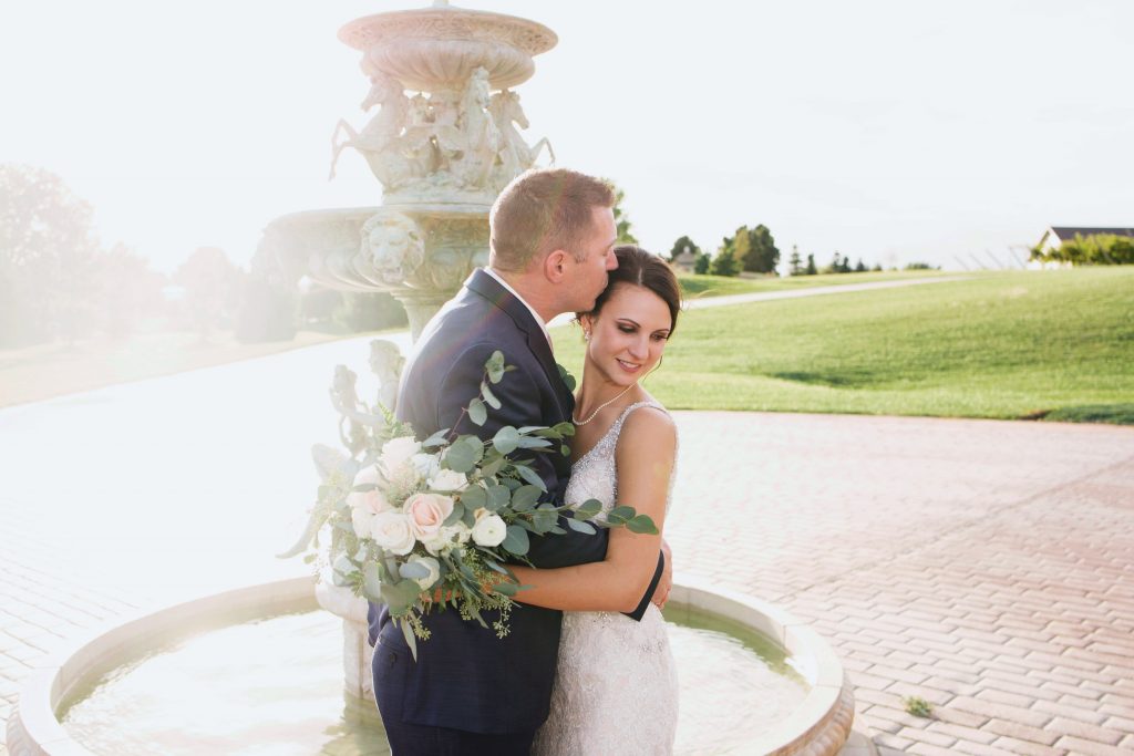 bride and groom with fountain outside