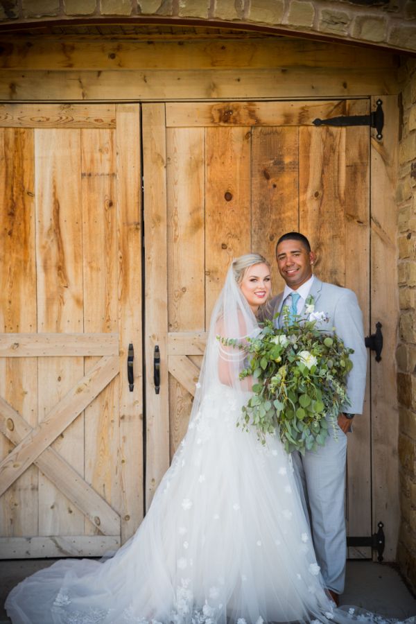 Bride and Groom posed out the front of the Stone Hill Barn Venue, Augusta KS.