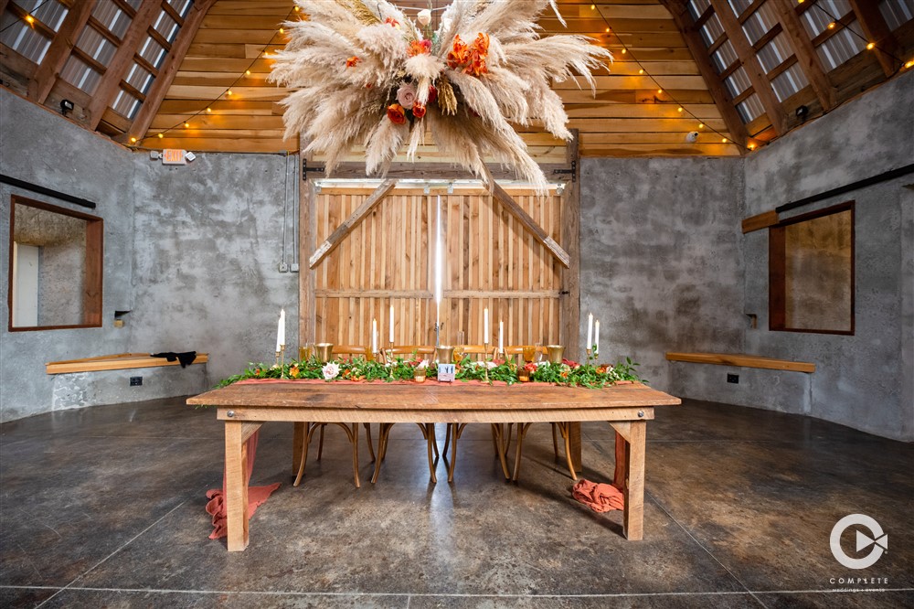 head table with pampas grass hanging above