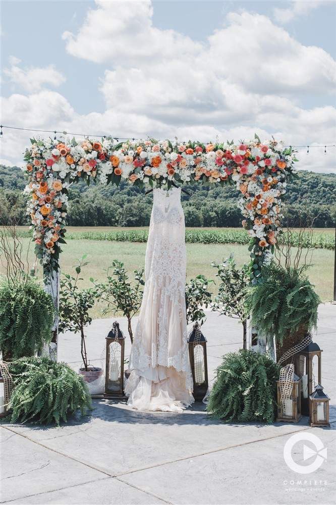 wedding dress hanging at ceremony altar